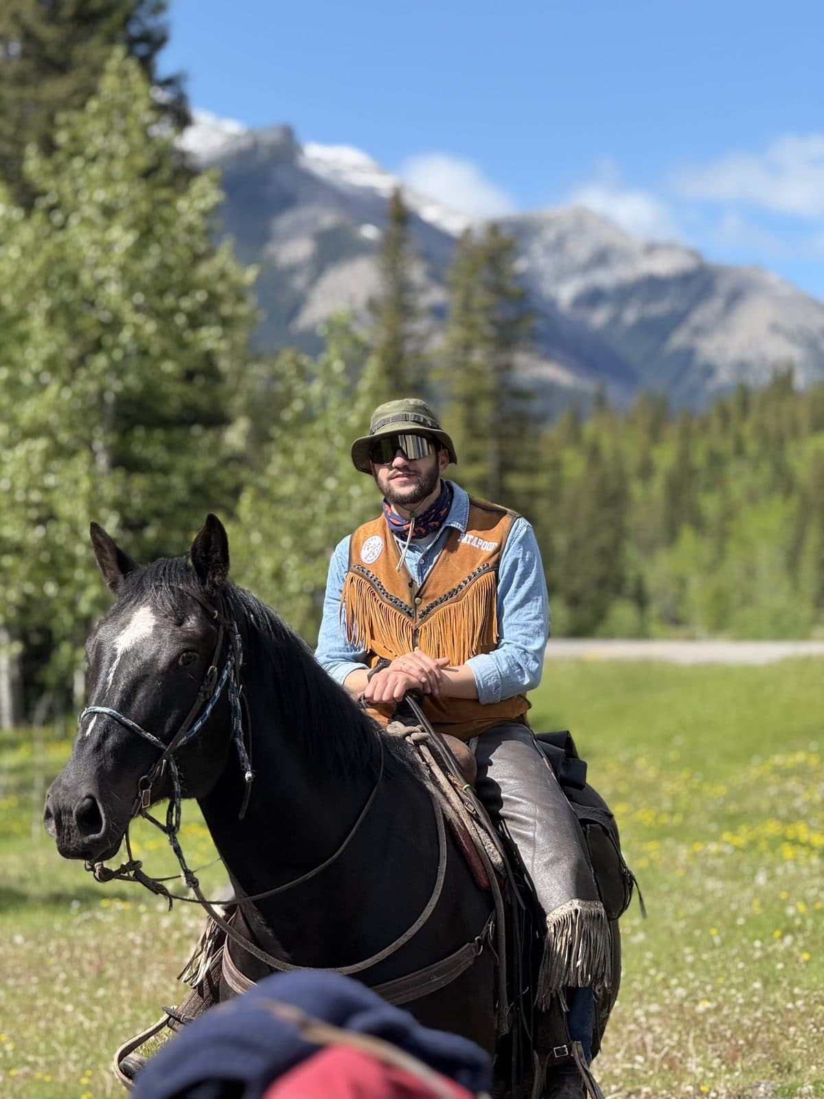 Patrick on horseback below the mountains